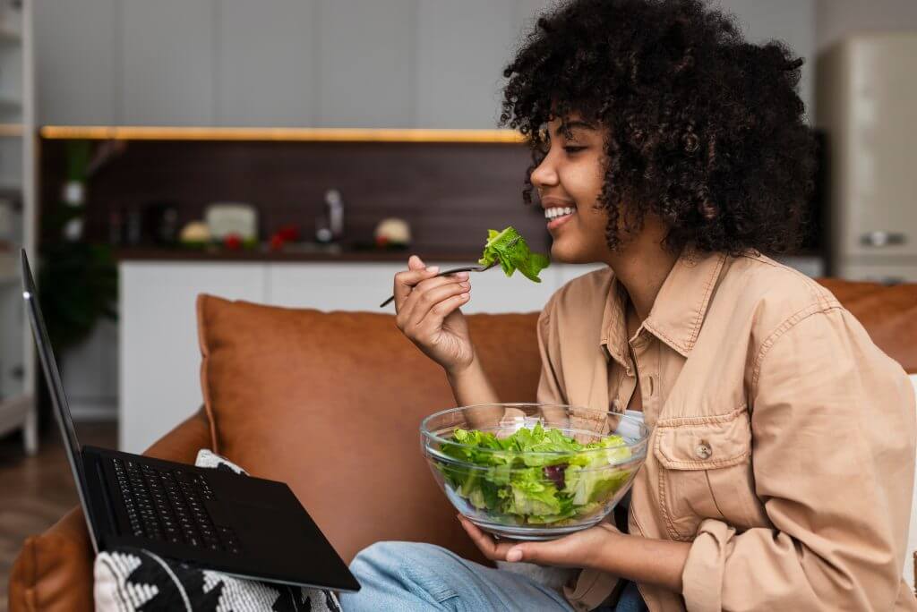 Woman relaxing on a couch eating a salad