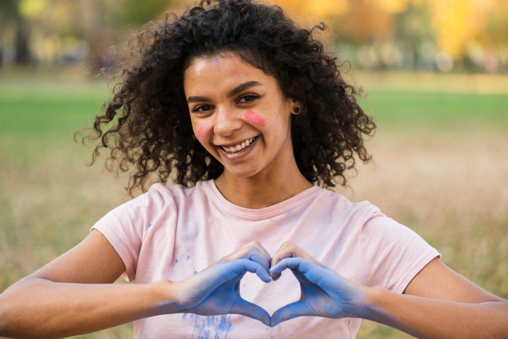 Smiling woman making a heart shape with her hands
