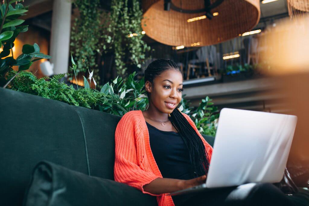 African American woman working on a laptop in a cafe