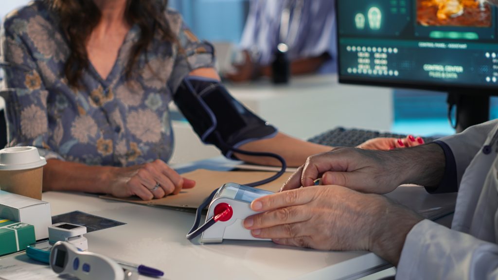 Doctor checking an elderly patient's blood pressure