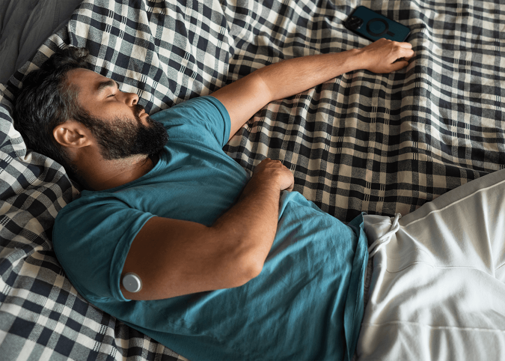 Diabetic man wearing a glucose sensor patch on his arm